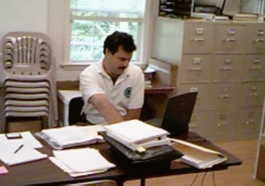 Previous business manager Mr. Dennis DiBello working at a desk
